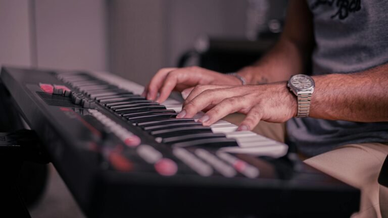 A close-up view of an adult playing a modern electric piano indoors, capturing the focus on their hands and the instrument.